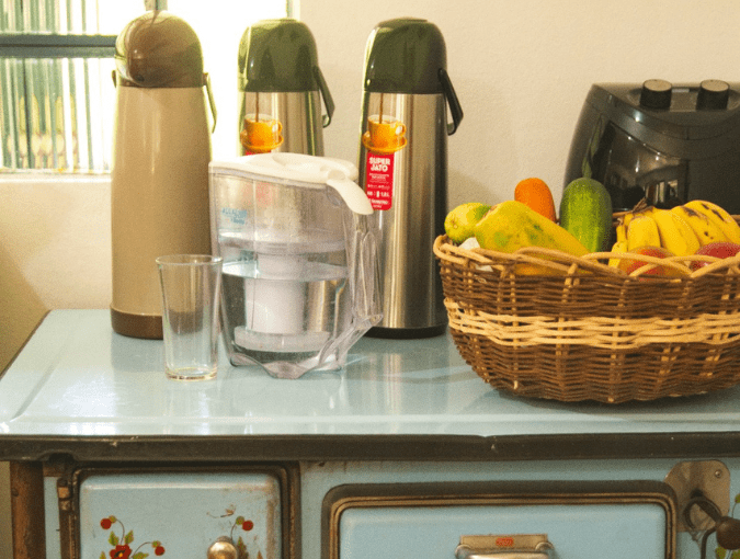 Fogão da cozinha do Hostel Parada dos Caminhantes com frutas e café sobre a bancada